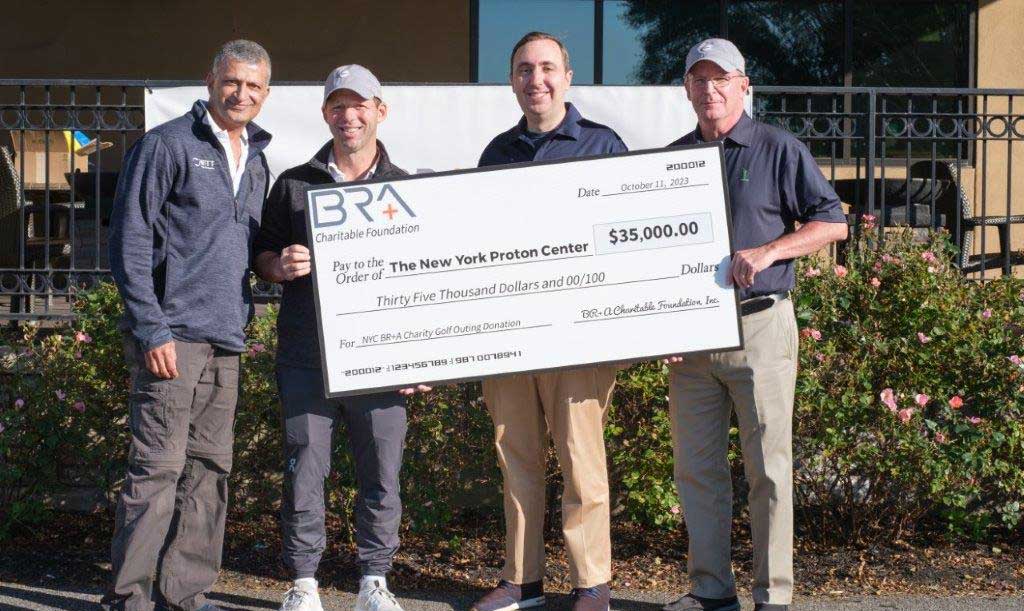 A group of four men posing with a large check, representing the $35,000 raised to help NYPC patients address non-clinical financial needs during treatment.