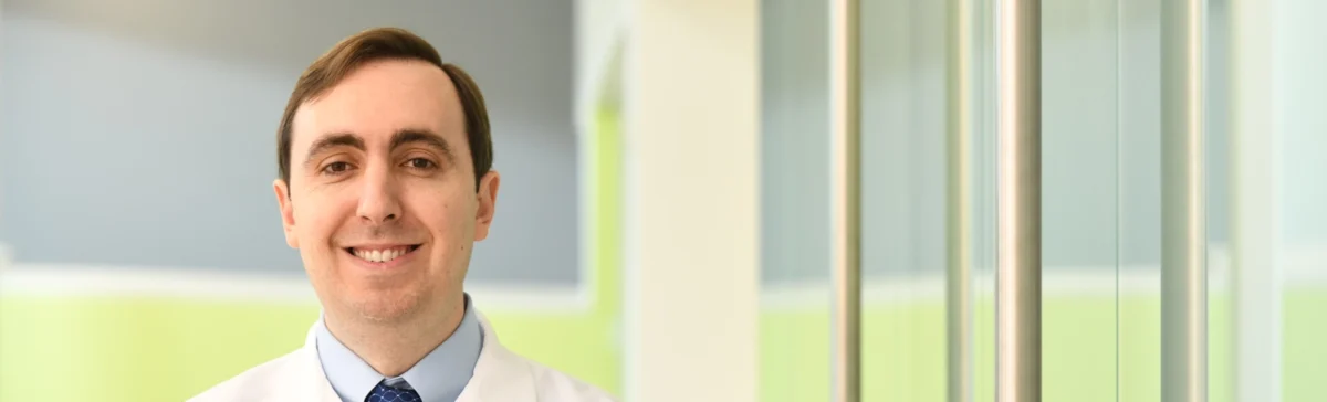 Portrait of Dr. Charles B. Simone, II, Chief Medical Officer of the New York Proton Center smiling and wearing a lab coat.