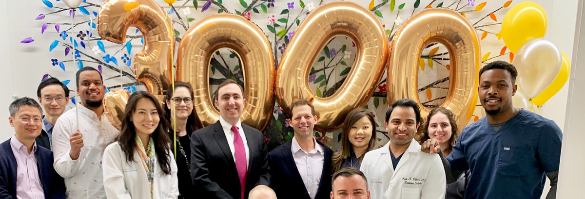 New York Proton Center employees celebrate 3rd Anniversary with gold balloons in background