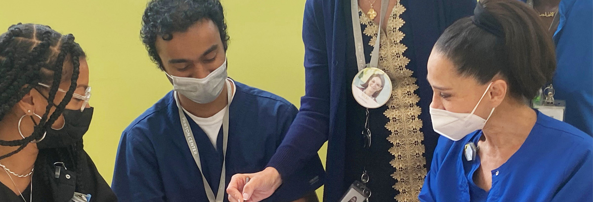 Four medical professionals conferring around a table