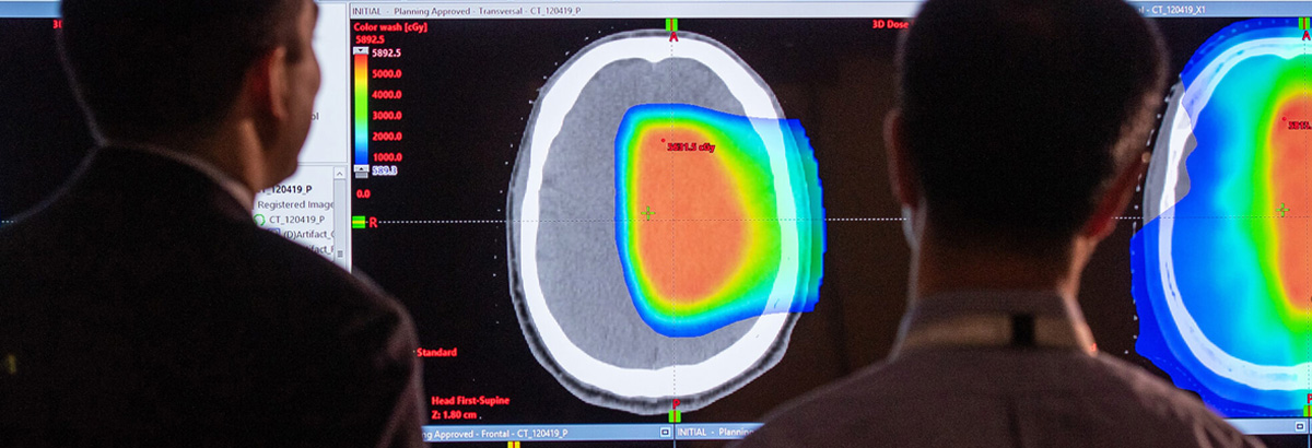 Physicians studying colorful scan on large screen