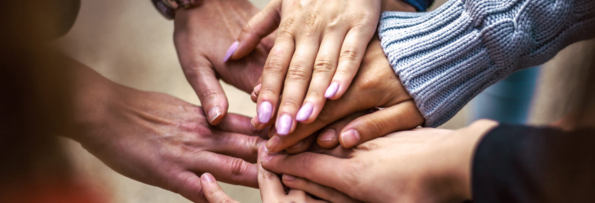 Several friends with hands clasped on top of each other