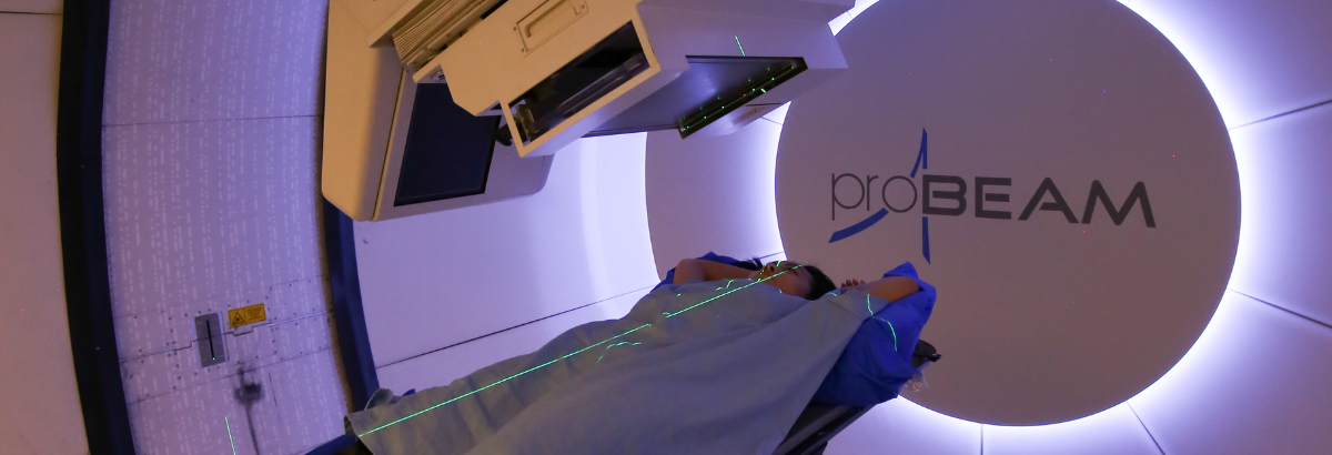 Patient on treatment couch in Varian ProBeam gantry room.